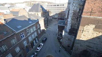 Une cour avec une fontaine, entourée de bâtiments historiques et d’une tour en pierre.