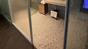 Une salle de bain moderne avec une douche à parois de verre, un meuble-lavabo avec un miroir et un porte-serviettes.