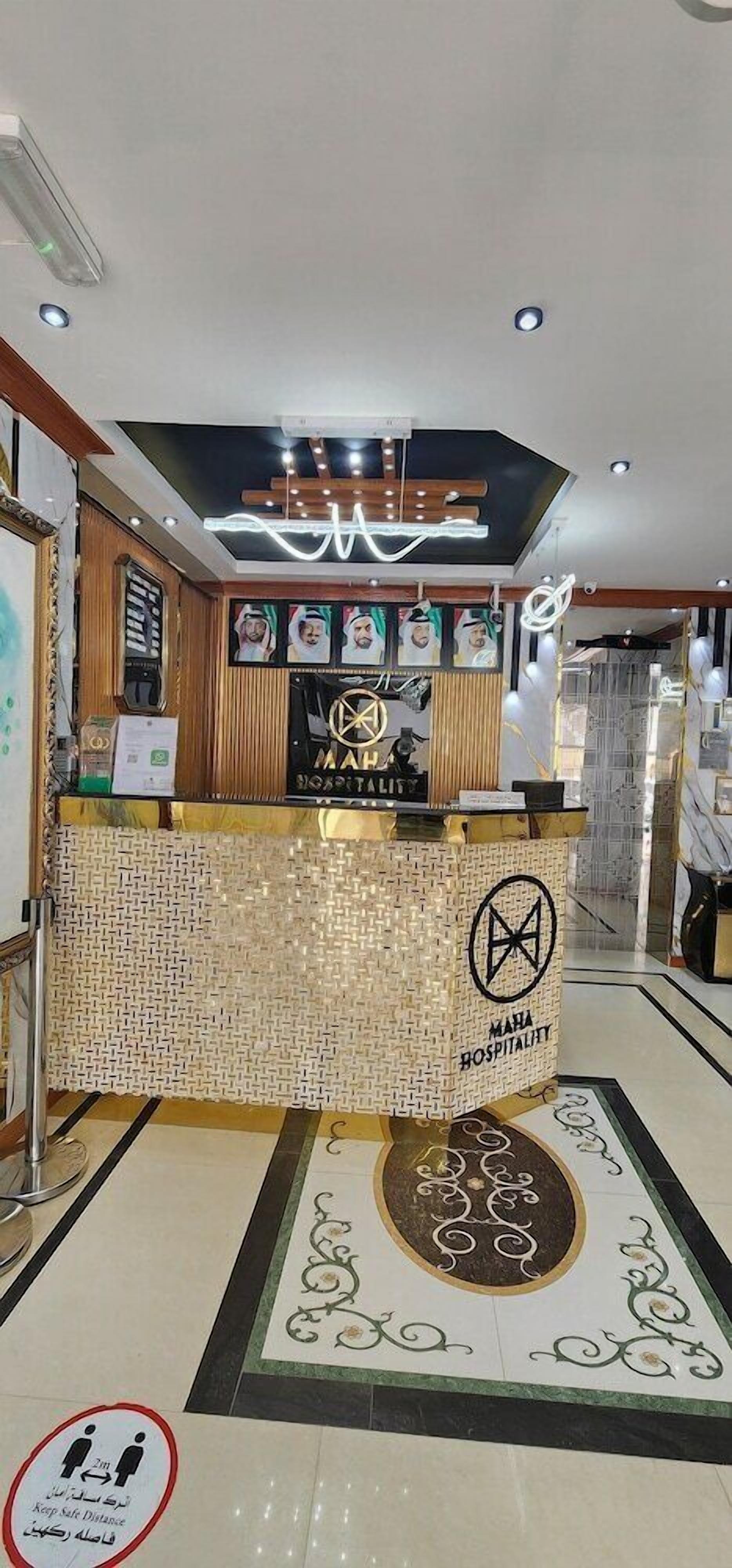 A reception area with a tiled counter, a logo, and a sign indicating a 2m safe distance.