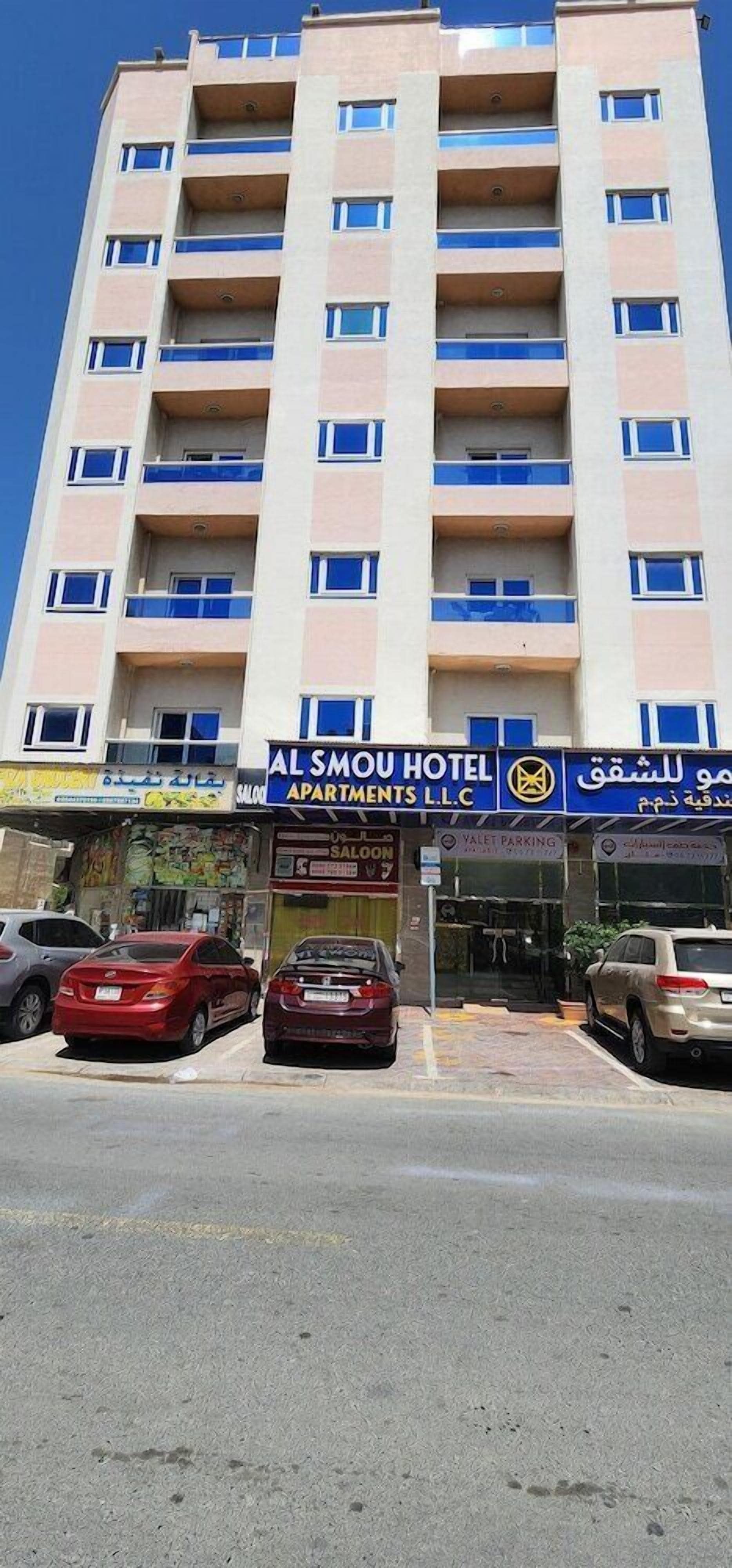 A multi-story hotel with balconies, a sign for Al Smou Hotel, and valet parking.