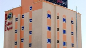 Un hotel de varios pisos con un letrero que indica que es el Hotel Al Smou.