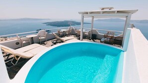 A pool area with lounge chairs and a pergola overlooking a body of water. - Kafieris View (Santorini)