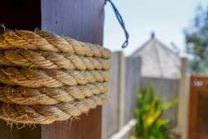 Ein Detailaufnahme eines Seils, das um einen Holzpfosten gebunden ist.