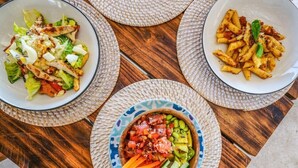 Three bowls of food on a wooden table. - Blue Lagoon Avia Villas (Ceningan Island)