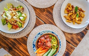 Drei Schüsseln mit Essen auf einem Holztisch.