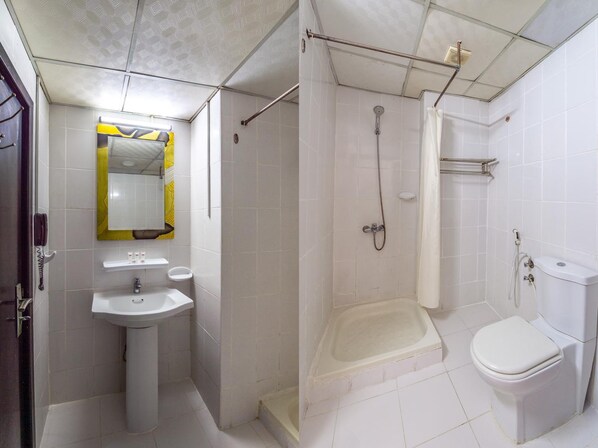 A bathroom with a sink, toilet, and shower. - Mermaid Beach Hotel (Ajman)