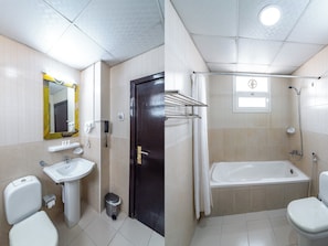 A bathroom with a toilet, sink, and shower. - Mermaid Beach Hotel (Ajman)