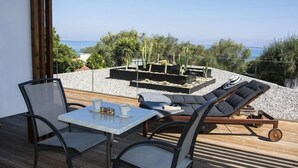 A balcony with a table and chairs, a sun lounger, and a cactus garden. - Ionian Eye (Corfu)