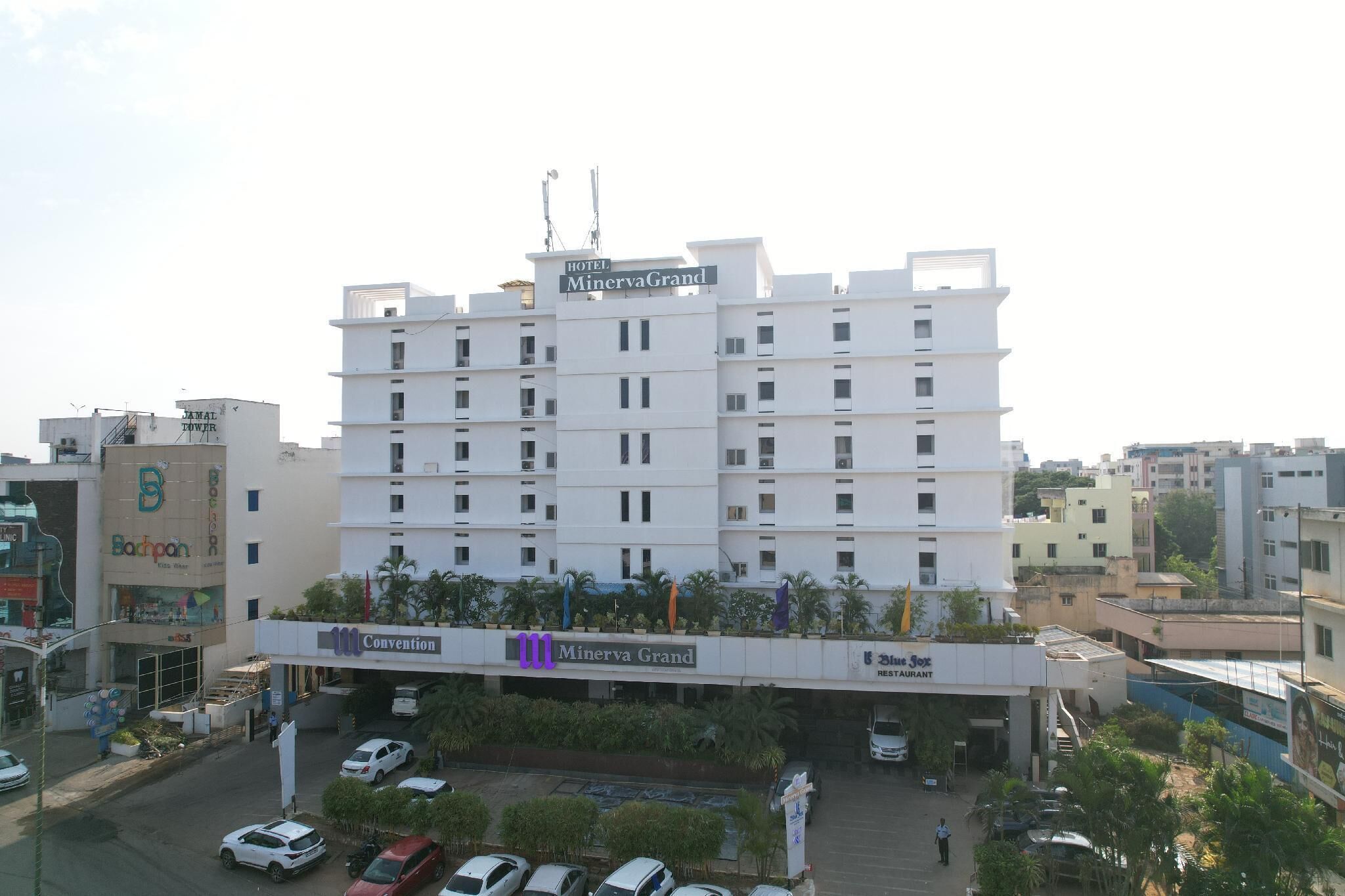 A multi-story hotel with a sign reading "Hotel Minerva Grand."