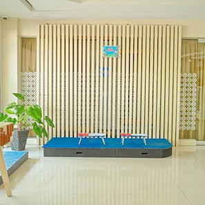 Ein Kinderspielbereich mit einer Spieledecke, einem Schild und einem Blumentopf.