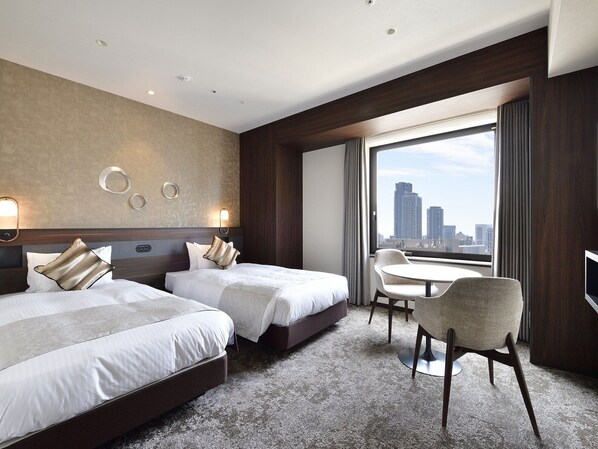 A hotel room with two beds, a dining table, and a city view. - Hotel Elcient Osaka (Osaka)