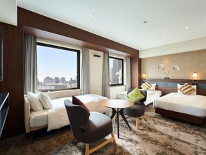 A hotel room with two beds, a sofa, a small table, and a view of the city. - Hotel Elcient Osaka (Osaka)