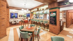 A restaurant with a brick wall, wooden ceiling, and a bar area with a sign. - Graphic Hotel Novy Jicin (Novy Jicin)