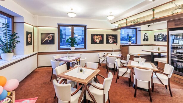 A hotel lobby with multiple seating areas, a reception desk, and artwork on the walls. - Graphic Hotel Novy Jicin (Novy Jicin)