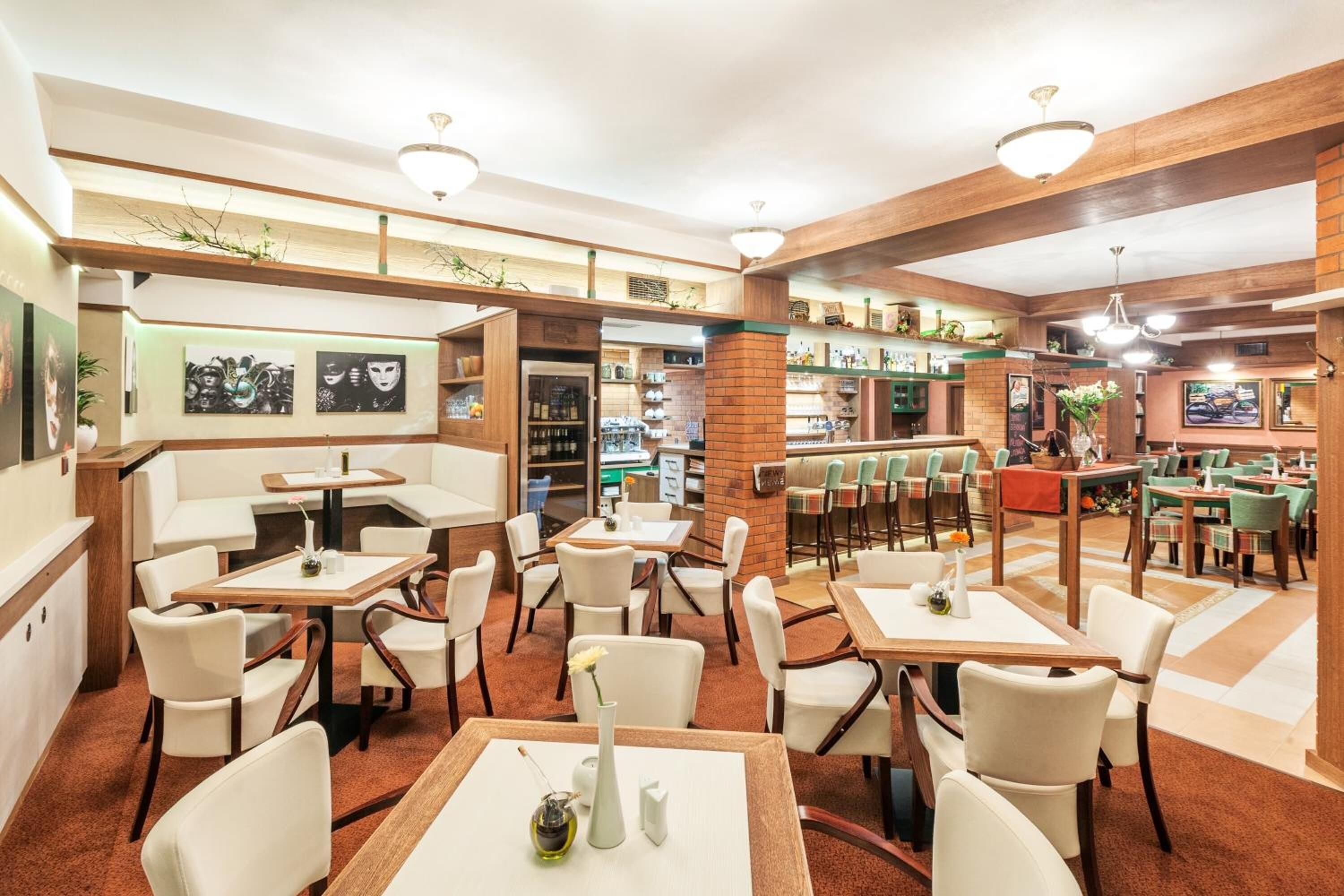 A restaurant with multiple seating areas, including booths and tables, with a variety of chairs and a bar area.