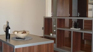 A modern kitchen with a central island, wooden cabinets, and built-in shelves. - Graphic Hotel Novy Jicin (Novy Jicin)