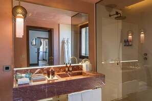 A bathroom with a large mirror, marble sink, and a glass shower enclosure. - Ca di Dio (Venice)
