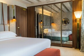 A hotel room with a large bed, a wardrobe, a mirror, and a wall-mounted lamp. - Ca di Dio (Venice)