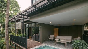 Un espace piscine extérieur moderne, doté d’une terrasse en bois, d’un canapé et d’une table basse.