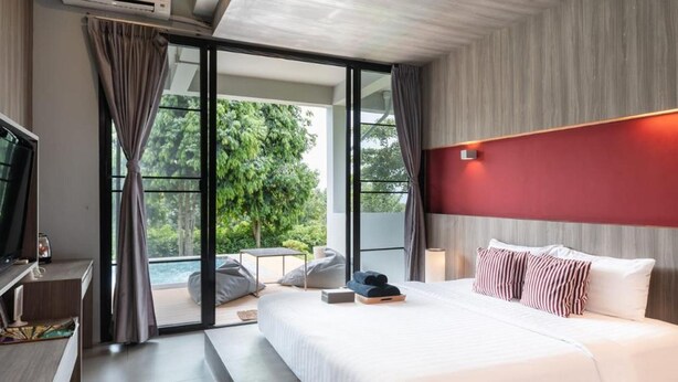 Une chambre d’hôtel moderne avec un grand lit, une télévision et une vue sur l’extérieur.
