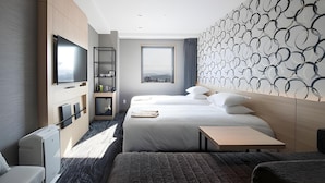 A hotel room with a bed, a TV, a desk, and a view of the city. - Tmark City Hotel Kanazawa (Kanazawa)