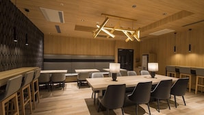 A modern conference room with wooden paneling, a high ceiling with exposed beams, and a central table with chairs. - Tmark City Hotel Kanazawa (Kanazawa)