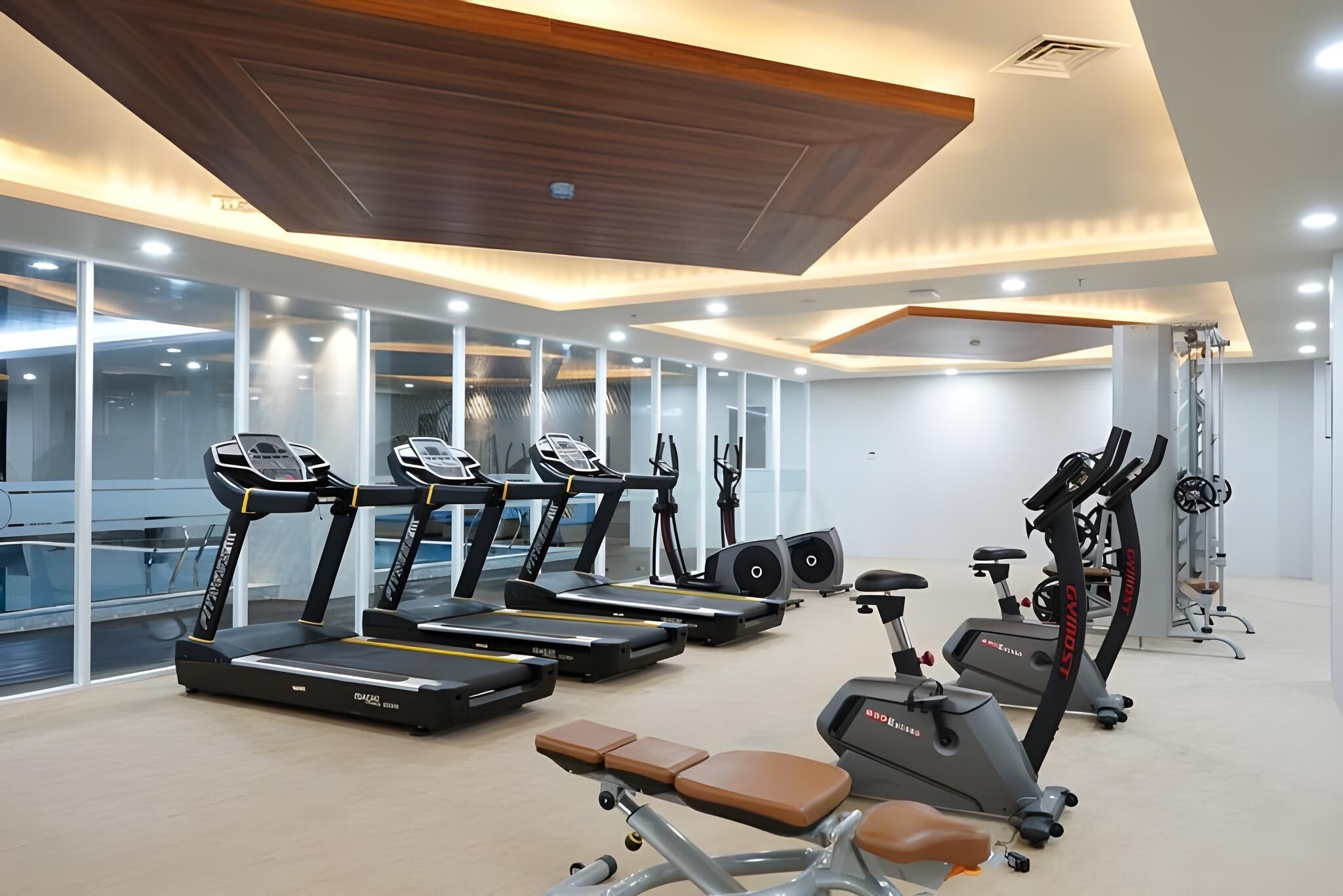 Een moderne sportschool met loopbanden, hometrainers en krachttoestellen.