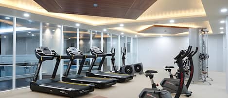Un gimnasio moderno con cintas de correr, bicicletas estáticas y máquinas de pesas.
