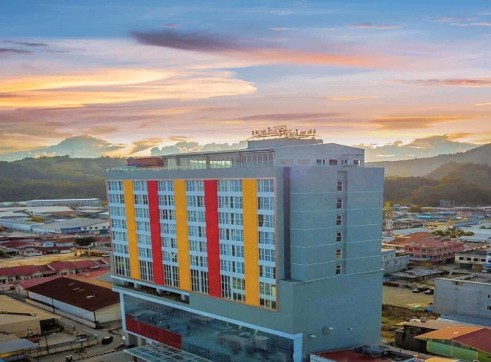 A multi-story hotel with a flat roof and a sign at the top.