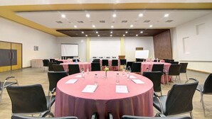A conference room with round tables, black chairs, and a whiteboard. - Mystic Valley Spa Resort (Igatpuri)