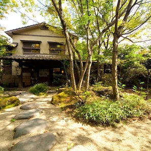 Una casa tradicional japonesa con un sendero de piedra que lleva a la entrada.