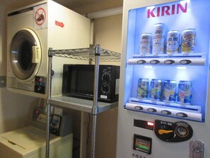 Ένας αυτόματος πωλητής με μπύρα Kirin και σνακ, ένας φούρνος μικροκυμάτων και ένα πλυντήριο ρούχων.