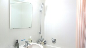 A bathroom with a sink, mirror, shower, and a towel rack. - Hotel Folkloro Kakunodate (Senboku)