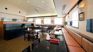 A restaurant with wooden tables and booths, a counter with a display, and large windows providing natural light. - Hotel Folkloro Kakunodate (Senboku)