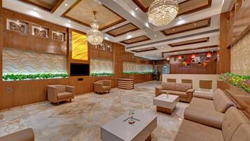 Eine geräumige Lobby mit Marmorboden, Holzvertäfelung und einer großen Chandelier.