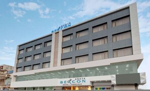 A multi-story hotel with a modern design, featuring a prominent 'Beacon' sign at the entrance. - Anaya Beacon Hotel (Jamnagar)