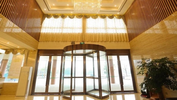 A lobby with a revolving door, large windows, and a chandelier. - Greentree Inn Anqing Huaining County Development Zone Duxiu Road (Anqing)