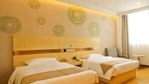 A hotel room with two beds, a wooden headboard, a bedside table with a phone, and a small round table. - Greentree Inn Anqing Huaining County Development Zone Duxiu Road (Anqing)