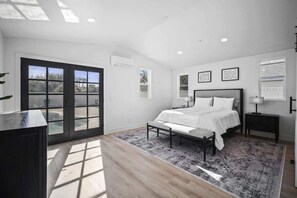 A bedroom with a bed, a nightstand, a desk, a window, and a door. - Aether - Sparkling Pool & Games - Mins to Old Town (Scottsdale)