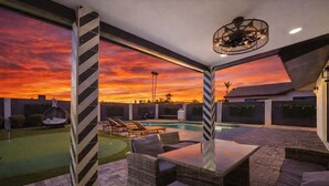 Eine Terrass mit Pool, Liegestühlen und einem Tisch.