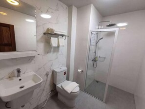 Ein Badezimmer mit Marmorwaschbecken, Toilette und einer Duschkabine.