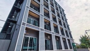 Un immeuble à plusieurs étages doté d’une architecture moderne, avec des balcons et de grandes fenêtres.