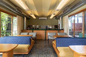 Un café avec des tables, un comptoir et une vue sur l’extérieur.