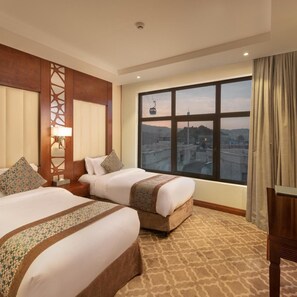 A hotel room with two beds, a large window with a city view, and a wooden headboard. - Sarwat Park Hotel (Abha)