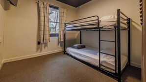 A bunk bed room with a window, curtains, and carpeted floor. - THE RED Lodge INN (Red Lodge)