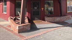 A building with a red facade, a wooden shingle roof, and a sign indicating 'NO VACANCY'. - THE RED Lodge INN (Red Lodge)