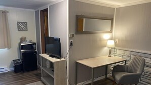 A compact room with a desk, chair, television, microwave, and small refrigerator. - Gateway Motel (Hart)