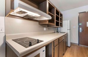 Une cuisine moderne dotée d’une cuisinière intégrée, d’armoires en bois et d’un réfrigérateur en acier inoxydable.