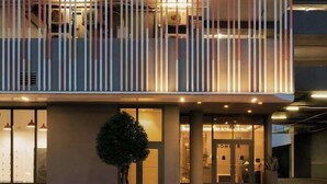 Un bâtiment moderne doté d’un toit plat, de grandes fenêtres et d’un balcon aux lignes verticales.