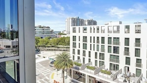Un hôtel moderne à la façade blanche, doté de nombreux balcons et offrant une vue dégagée sur le paysage urbain.